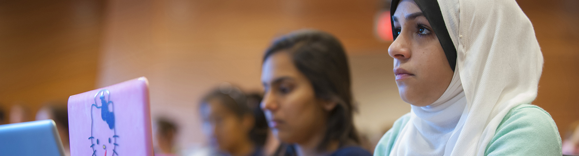 Students take notes on laptops during a lecture