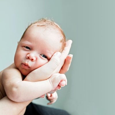 A baby's head held in adult hands